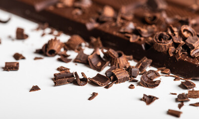 Curls and pieces of tasty chocolate on white table