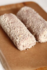 Uncooked meat roulade. Rolled meat with a filling of cheese and ham.