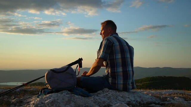 travel mountain hike young male hiker drinking water and looking at beautiful natural scenery in countryside spbd. Rear view of handsome american guy enjoying aqua and watching amazing views of