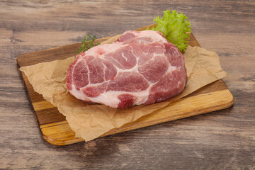 Raw pork steak over wooden board