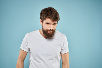 Obraz premium Man in white t-shirt emotions facial expression cropped view studio blue background lifestyle