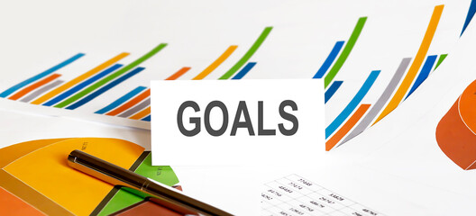 GOALS text on paper on chart background with pen