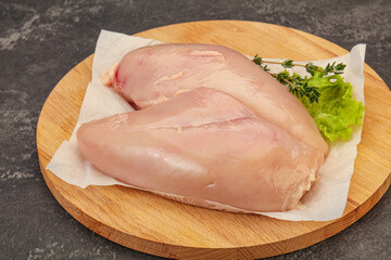 Raw chicken breast over board