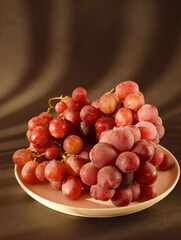 Fresh natural organic red grapes on a black background with shadows