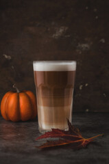 Autumn latte coffee pumpkin on dark background.