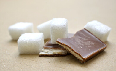 close up of sugar cubes on brown background