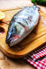 Raw fish on a chopping Board close-up with a slice of lemon.Texture or background