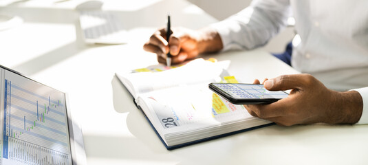 African Man Organizing Appointment Schedule Using Cellphone
