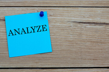 ANALYZE - acronym written on a blue sheet pinned to a wooden board