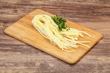 Chechil spaghetti cheese over board
