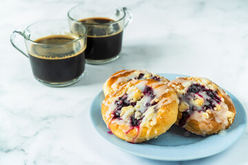 Buns stuffed on a blue plate, and coffee