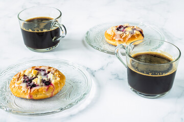Buns on plates and cups of coffee. Afternoon coffee. Coffee time.