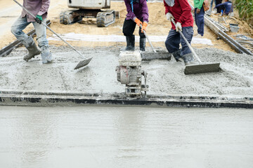 Pouring concrete with worker mix cement at construction site