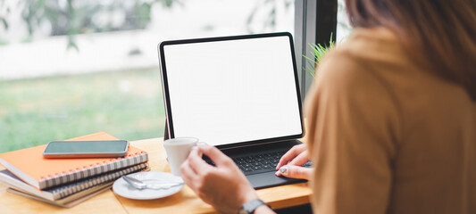 Mockup blank white desktop screen tablet with a woman working in background. White screen tablet for graphic montage.