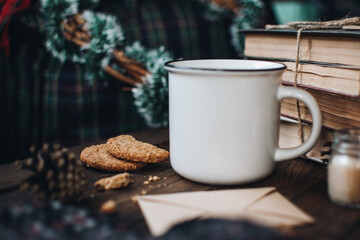 Scandinavian hygge styled Christmas composition. Cozy winter homely scene with books, cup of tea or coffee, cookies, cinnamon sticks and knitted things. Santa Claus working place. Flatlay. Home decor.