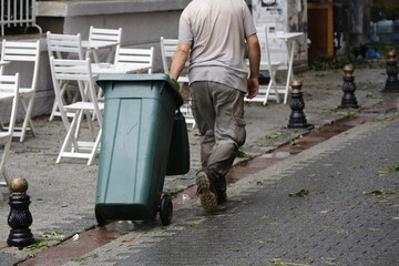 Worker shedding garbage on a rainy day
