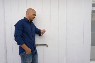 man waiting and looking at his watch, white background