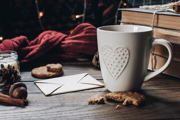 Scandinavian hygge styled Christmas composition. Cozy winter homely scene with books, cup of tea or coffee, cookies, cinnamon sticks and knitted things. Santa Claus working place. Flatlay. Home decor.