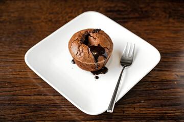 Chocolate fondant dessert on a white plate and a fork