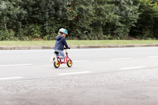 enfant roulant en draisienne sur la route
