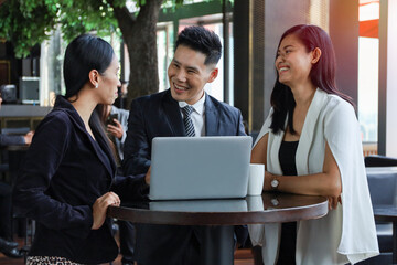 Executive business people talking and discussing with partner or colleagues in co-working space area, brainstorming and meeting team by using laptop or tablet concept