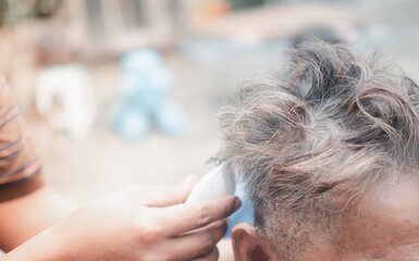 Obraz na płótnie Canvas Elegant middle aged man getting haircut in home during Coronavirus outbreak