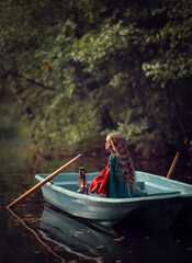 Fototapeta premium Young woman with lantern in the boat