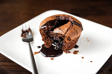 Chocolate fondant dessert on a white plate and a fork