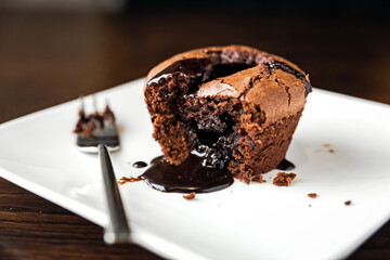 Chocolate fondant dessert on a white plate and a fork
