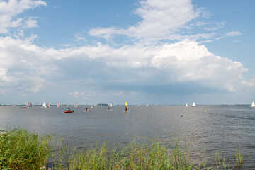 windsurfers on lake in summer on a sunny day with beautiful summer sky