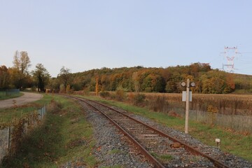Voie de chemin de fer unique avec traverses en bois de type vignole, au milieu de la campagne en automne,  ville de Saint Quentin Fallavier, département de l'Isère, France