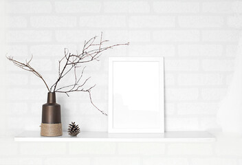 empty frame and vase of dry flowers in white wall