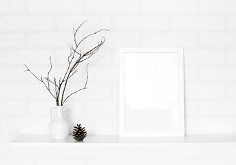 empty frame and vase of dry flowers in white wall