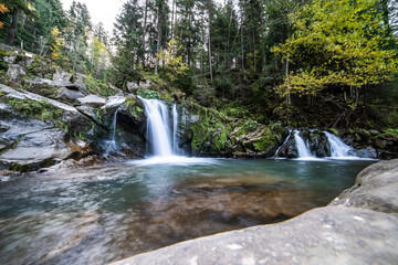 Waterfall on a mountain river in the autumn forest