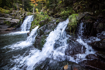 Naklejka premium Waterfall on a mountain river in the autumn forest