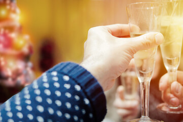 Hands holding glasses and toasting with champagne at Christmas or New Year. Selective focus