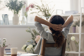 Back view of female employee decorator relax in chair at home office or atelier dream or visualize....