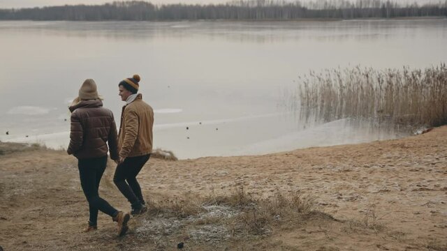 Sweet couple walking nearby autumn lake. Love, relationship, family concept. Filmed on cinema camera. 12 bit color space.