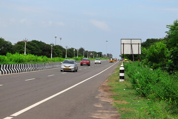 red cars and white cars with yellow auto on the india highway