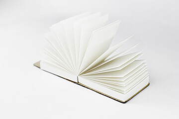 Fan unfold open small notepad with blank light beige pages. Notebook, sketchbook. White backdrop. Minimalism