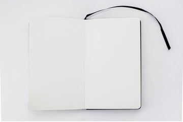 Unfold open notebook, book with blank white pages and black ribbon, bookmark on light background. Sketchbook. Top view