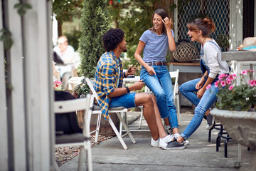 Obraz premium Cheerful friends chatting at the bar's backyard. Quality friendship time together