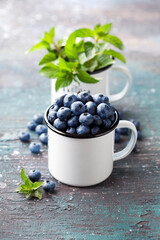 Fresh blueberries in a metal enamel mug, selective focus