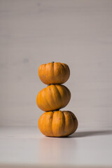 three pumpkins piled up on a wooden background