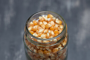 Close up of a glass jar full of corn grains placed on a tabletop. Eco friendly concept