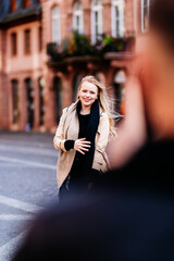 Young woman is photographed by her boyfriend with a cell phone and poses