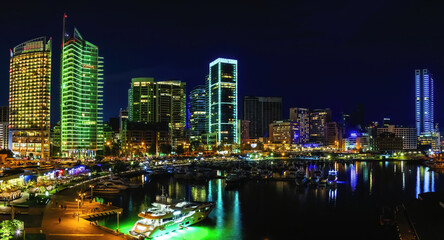 A panoramic photo of Beirut, Lebanon city skyline at night, featuring the vibrant neon lights of...