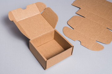 Brown cardboard box on grey background, opened, empty inside