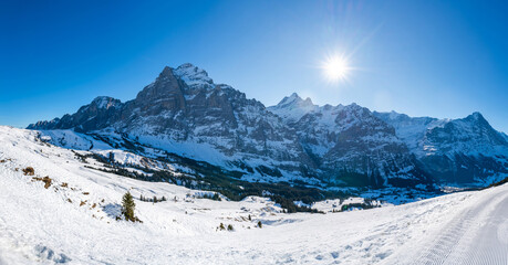 Wide panoramic view of winter landscape with snow covered peaks in Swiss Alps on the First mountain in Grindelwald, Switzerland