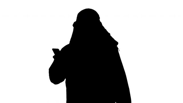 Arab man using his smartphone surfing on the internet or messaging while walking, Alpha Channel